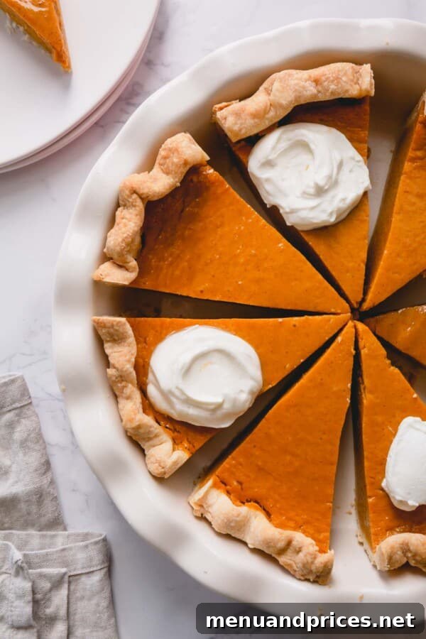 Velvet Pumpkin Dream Pie 2 Overhead shot of sliced pumpkin pie in a pie dish, showcasing its perfect texture.