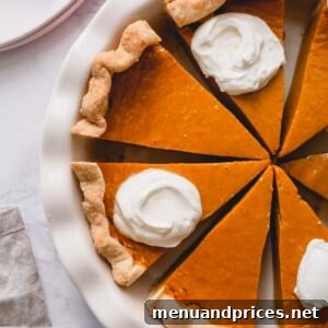 Velvet Pumpkin Dream Pie 6 Overhead shot of sliced pumpkin pie in a pie dish.