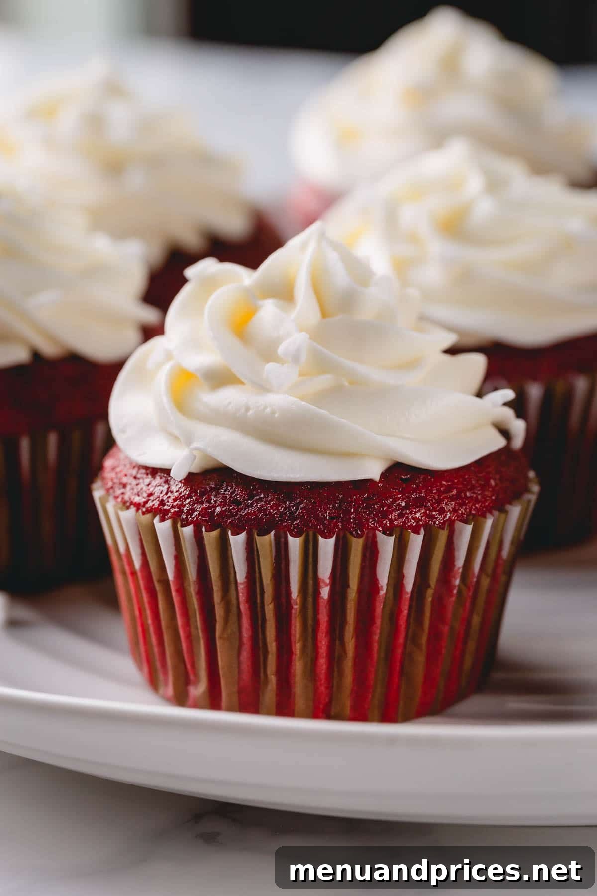 Velvet Dream Cupcakes 4 A close-up of a single red velvet cupcake, showcasing its rich red cake and fluffy cream cheese frosting.