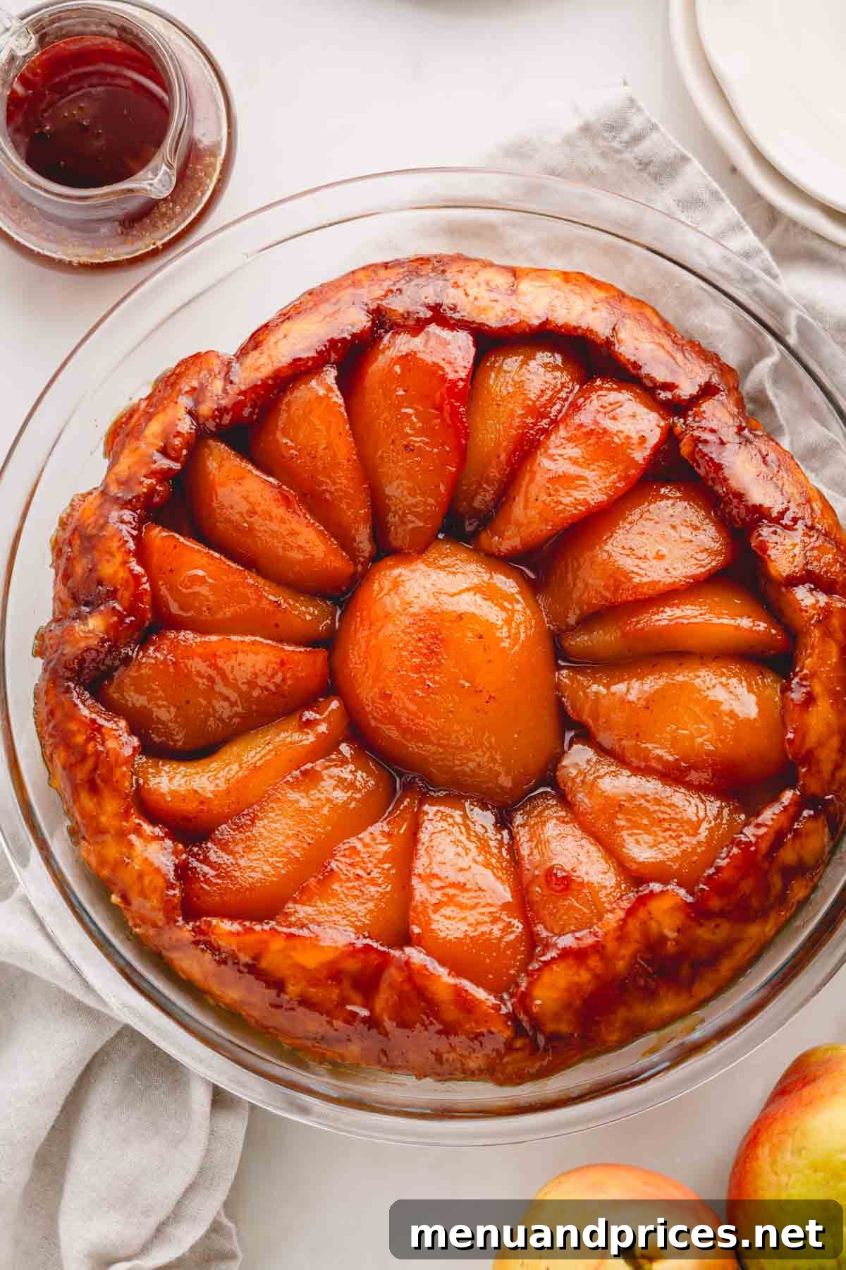 Overhead image of a pear tarte tatin in a glass baking dish, highlighting its rustic beauty.