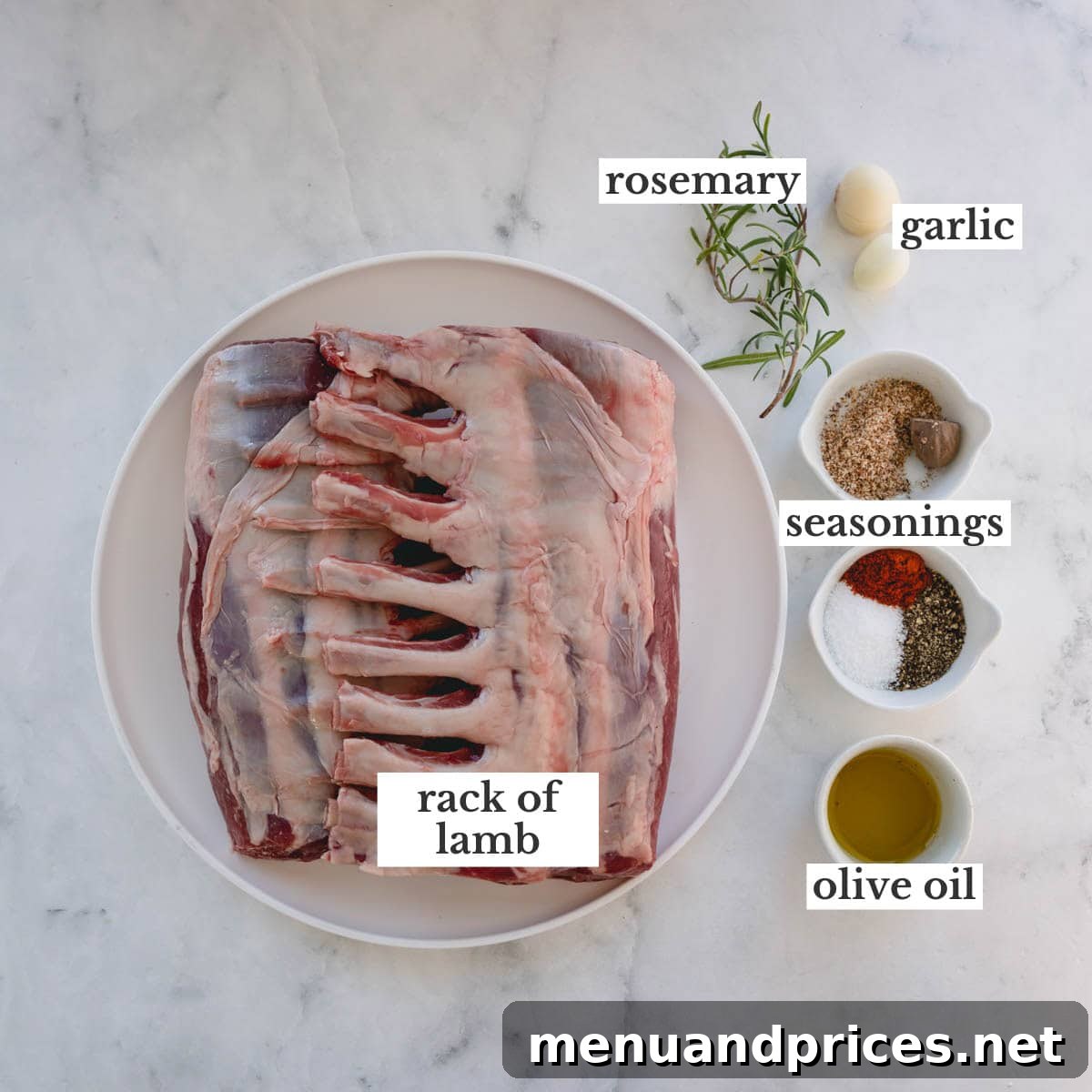 Herb-Crusted Lamb Rack 4 A selection of fresh ingredients including two frenched racks of lamb, whole garlic cloves, fresh rosemary sprigs, and various spices, laid out on a clean surface for preparation.