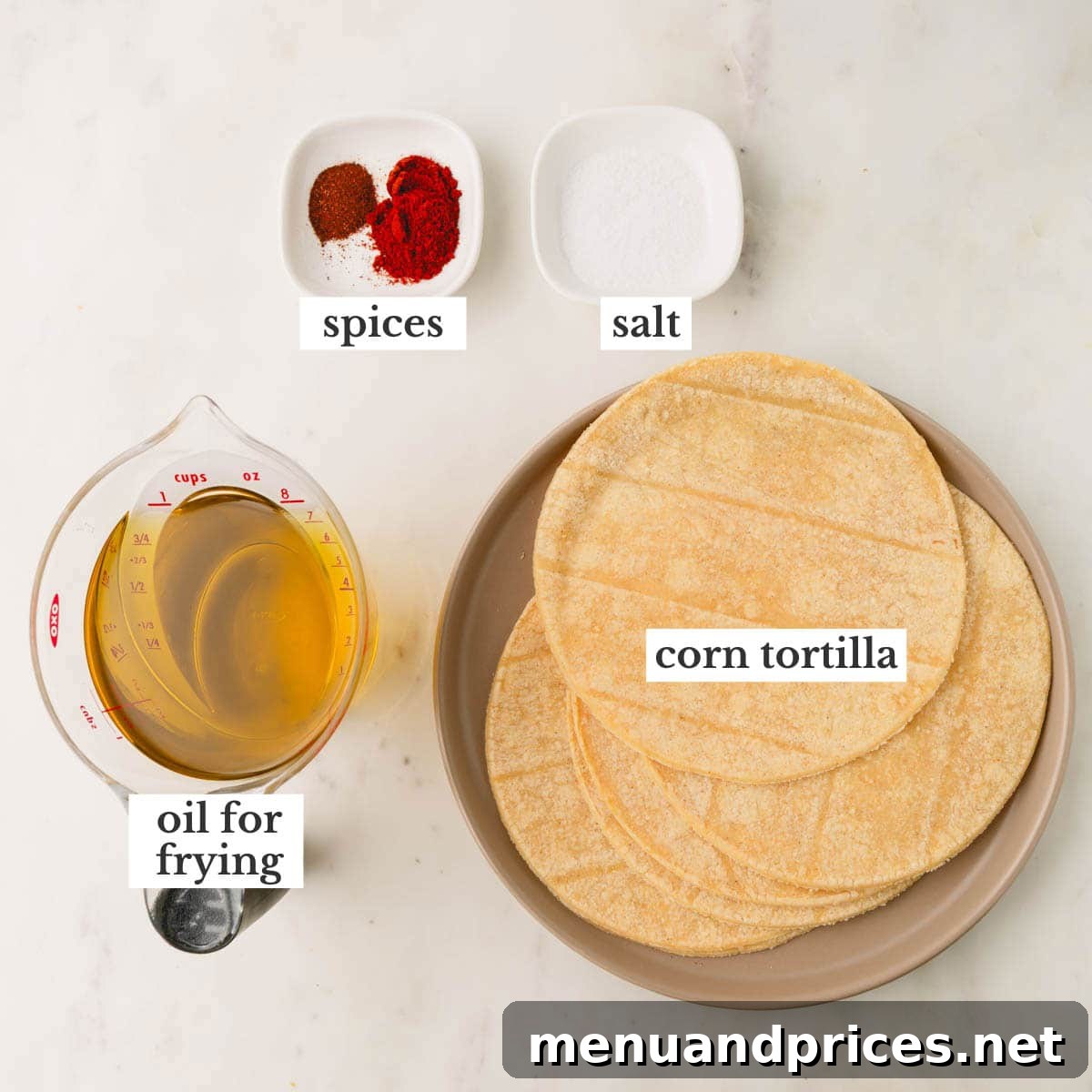 Zesty Handcrafted Tortilla Chips 4 A flat lay image displaying the raw ingredients: corn tortillas, a bottle of oil, and small bowls of salt, smoked paprika, and chili powder.
