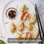 Plate of cooked beef dumplings with dipping sauce