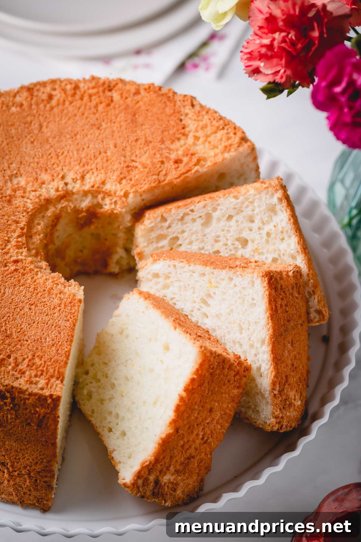 Light & Airy Angel Food Delight 7 A beautifully sliced Angel Food Cake resting on an elegant cake platter, ready to be served.