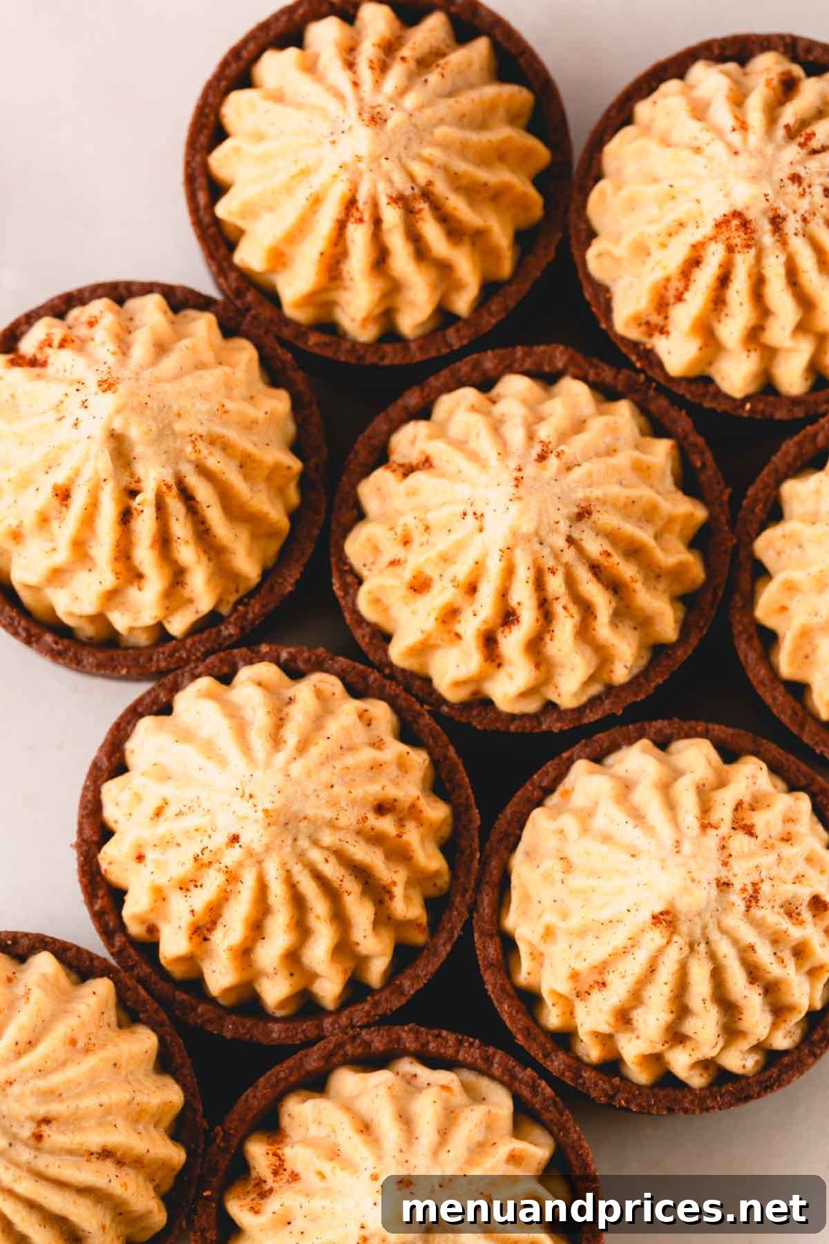Overhead image of chocolate cups filled with pumpkin mousse and topped with pumpkin spice.