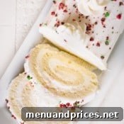 Sliced white roll cake topped with crushed red and green M&Ms.