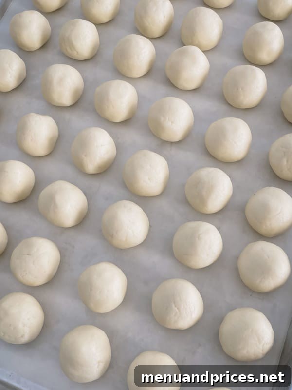 Enchanted Apple Cream Roll 9 White cake balls elegantly arranged on a baking sheet, showcasing their smooth finish, ready for dipping or serving.