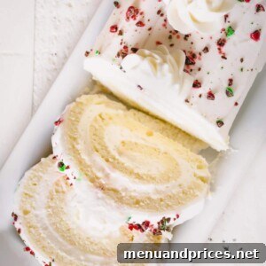 Sliced white roll cake topped with crushed red and green M&Ms.