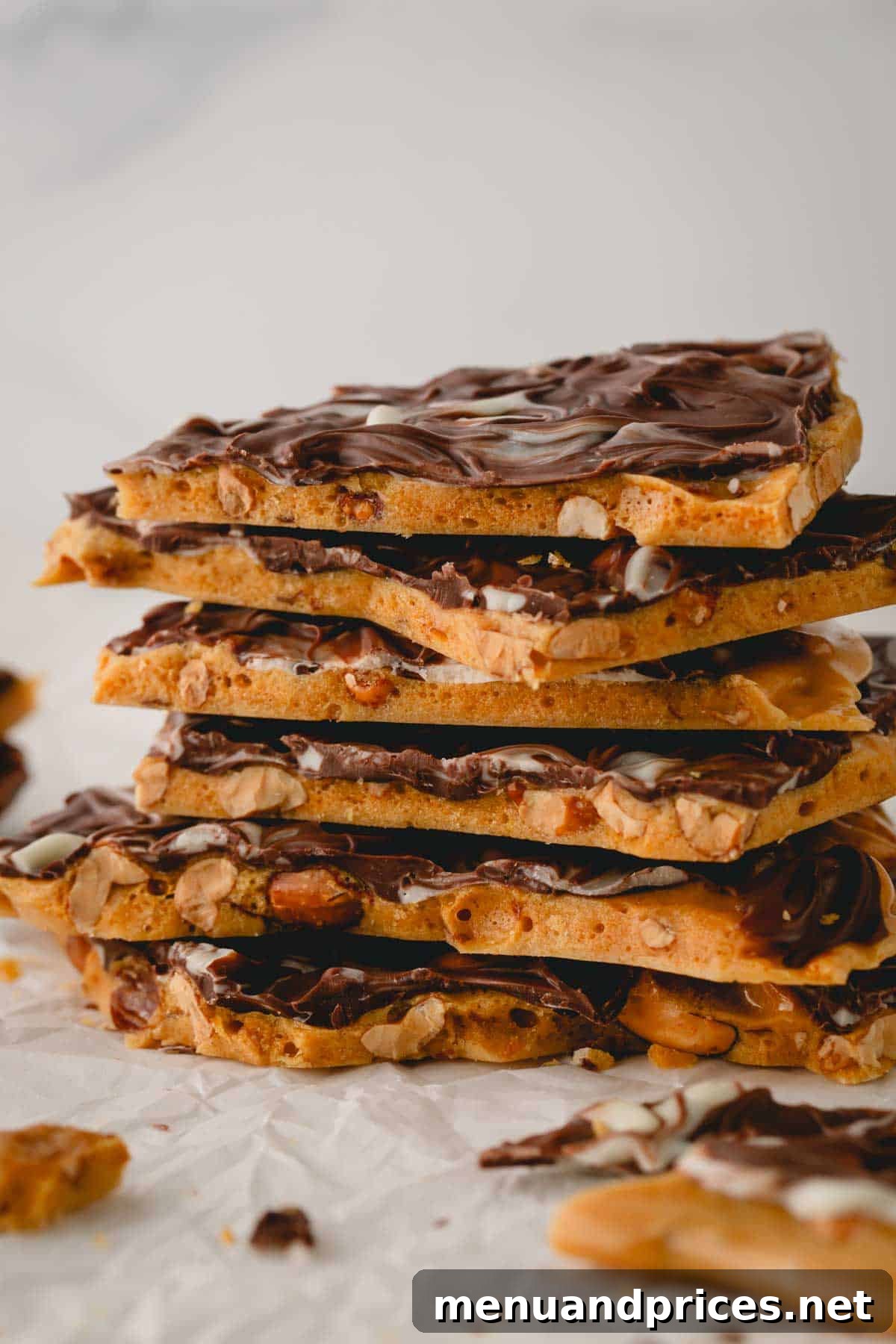Gourmet Chocolate Peanut Brittle 3 A beautifully arranged stack of chocolate peanut brittle pieces, showcasing their appealing golden-brown and dark chocolate layers.