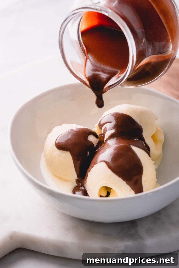 Dreamy Homemade Vanilla Ice Cream 11 Three scoops of vanilla ice cream generously drizzled with rich chocolate sauce, a classic dessert combination.