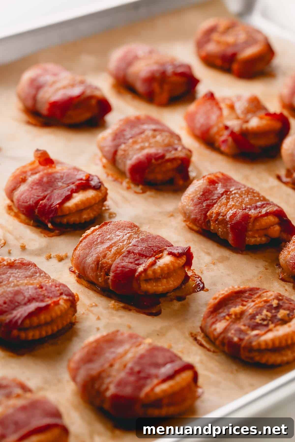 Bacon Cheddar Crisps 3 Golden-crisp bacon wrapped crackers cooling on a sheet of parchment paper on a baking sheet, showcasing their delicious texture.