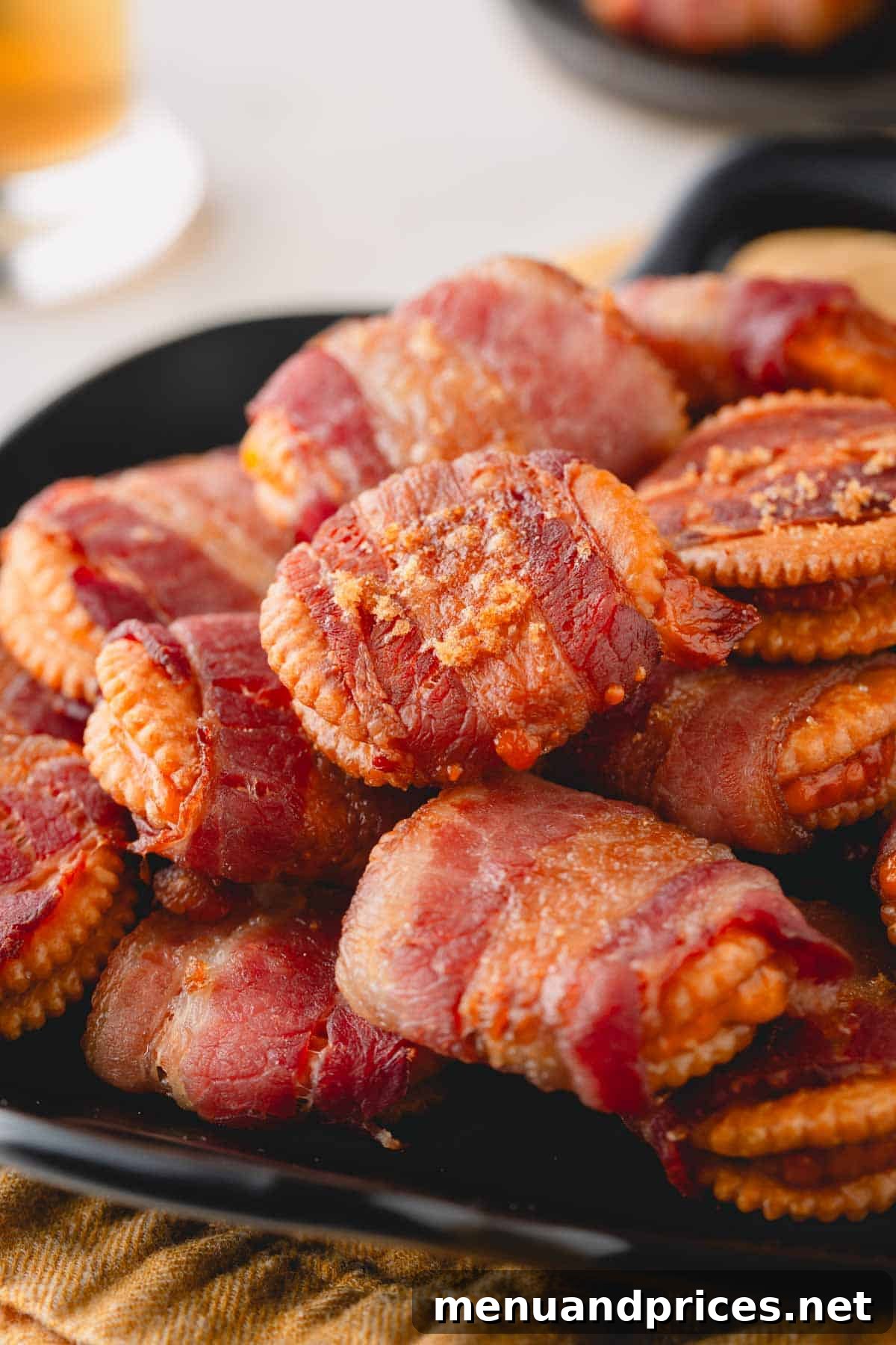 Bacon Cheddar Crisps 9 A close-up image of a vibrant plate overflowing with golden-brown cheesy bacon crackers, glistening with caramelized brown sugar.