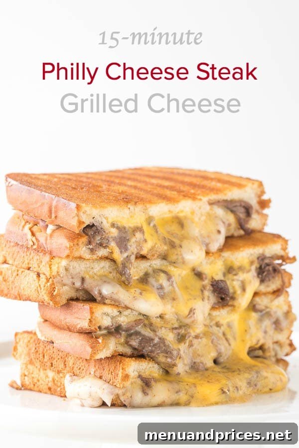 Cross-section view of a Philly Cheesesteak Grilled Cheese sandwich with melted cheese and steak