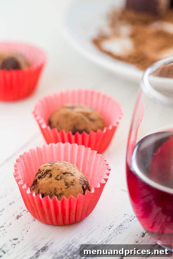 Two-Ingredient Boozy Truffles 4 Close-up of a homemade red wine truffle, showing its smooth, cocoa-dusted exterior, ready to be enjoyed