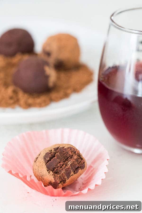 Two-Ingredient Boozy Truffles 5 A selection of two-ingredient red wine truffles lightly dusted with cocoa powder, arranged for a close-up