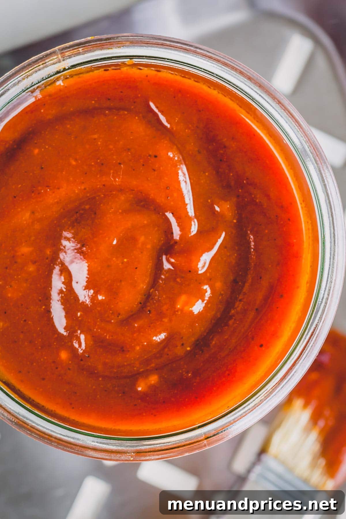 Crafting Your Perfect Homemade BBQ Sauce 3 A close-up shot of a jar of rich, homemade BBQ sauce from the top, showcasing its smooth texture.