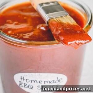 A jar of homemade BBQ sauce with a brush, ready for serving.