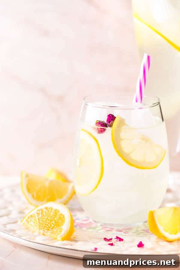 Rose-Kissed Lemonade 3 A tall glass of ice-cold rose lemonade, garnished with fresh lemon slices and delicate rose petals, ready for a summer day.