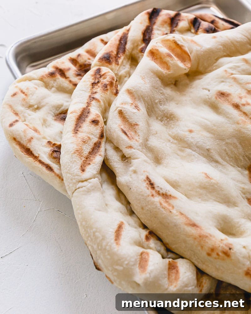 Enginarlı Izgara Pizza Sırları 8 Several grilled pizza crusts stacked neatly on top of each other on a baking sheet, ready for future use.