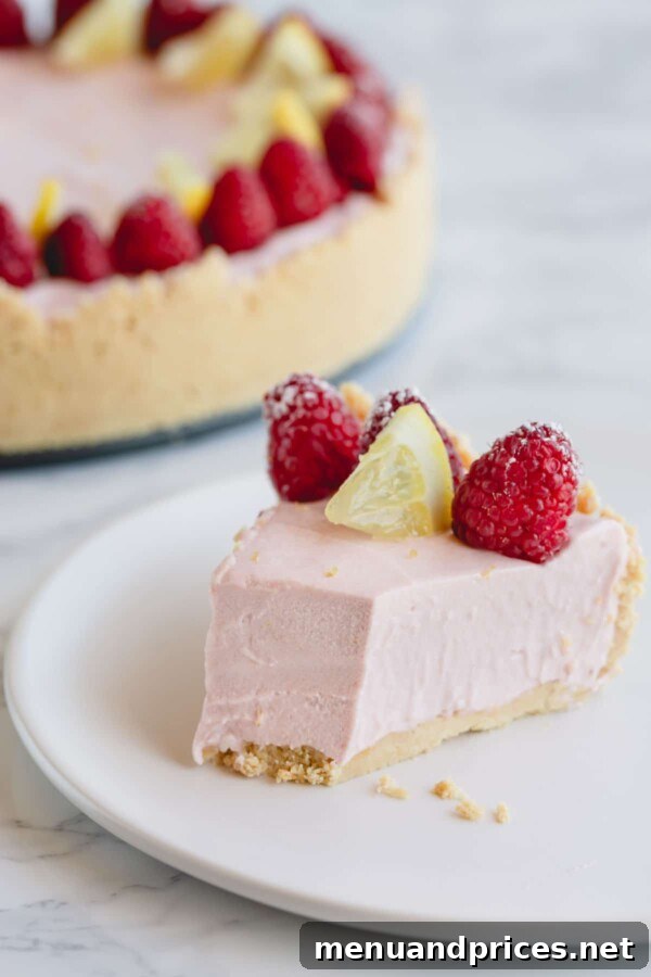 Zesty Berry No-Bake Cheesecake Bliss 7 A delectable slice of lemon raspberry no-bake cheesecake, beautifully presented with a small corner missing, showcasing its perfect sliceability and tempting filling.