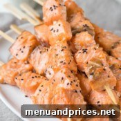Delicious Honey Sesame Salmon Kebabs plated with sides.