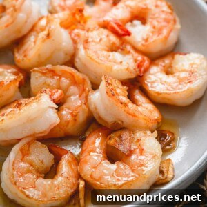 Garlic Butter Shrimp plated with pasta, garnished with fresh parsley.