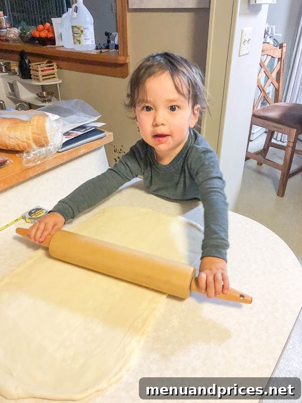 Culinary Chaos with a Curious Kid 10 Toddler boy Grant focused on helping roll out dough for pain au chocolat (chocolate croissants) in the kitchen