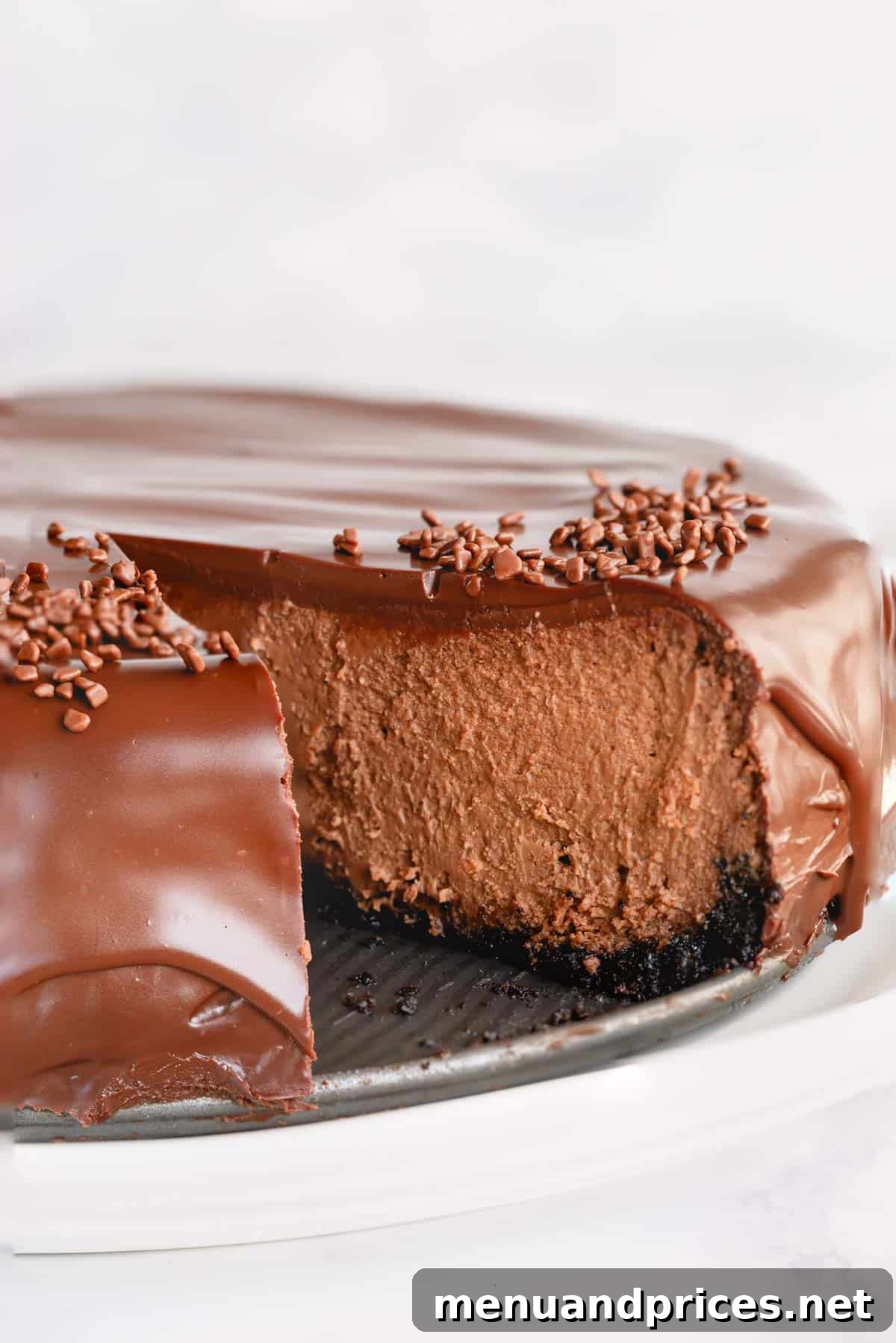 Velvet Chocolate Heaven Cheesecake 2 Supreme chocolate cheesecake with a slice missing, revealing its luscious layers.