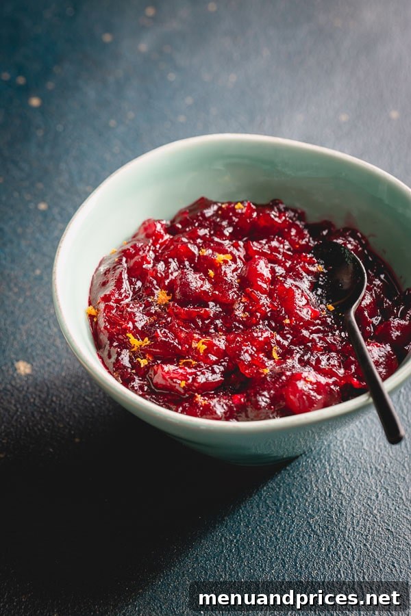 Zesty Orange Cranberry Sauce 3 Homemade orange cranberry sauce glistening in a deep blue bowl, ready to be served.