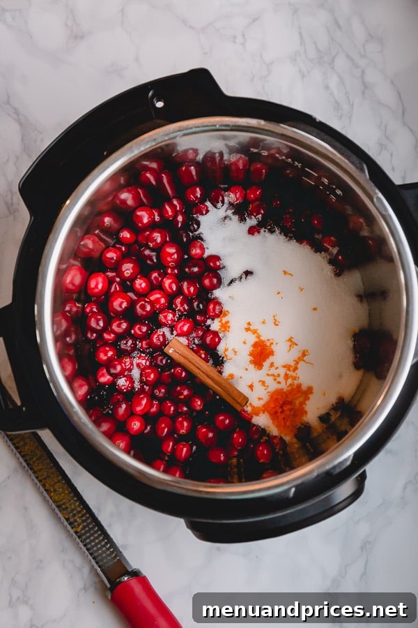 Zesty Orange Cranberry Sauce 6 Cranberry sauce ingredients being added to an Instant Pot's inner pot, highlighting the ease of preparation.