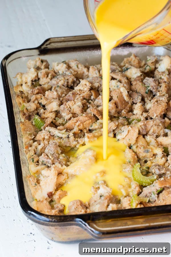 Post-Feast Stuffing Breakfast Bake 4 Egg mixture being carefully poured over a bed of sausage stuffing in a baking dish, preparing it for baking.