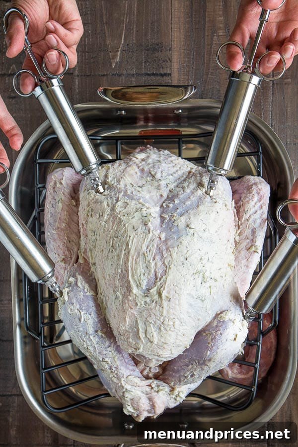 Thanksgiving Turkey Unlocked: From Novice to Roast Master 4 A raw whole turkey resting on a roasting pan, generously covered with melted butter and prepared for roasting, with four injectors visible in the thighs and breasts to enhance juiciness and flavor.