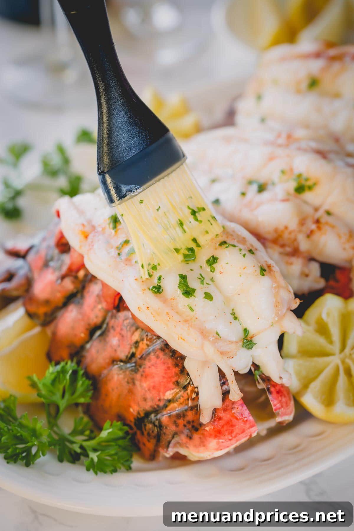 Perfectly Baked Lobster Tails 5 A hand brushing melted butter mixed with fresh parsley over a perfectly baked lobster tail, ready for serving.