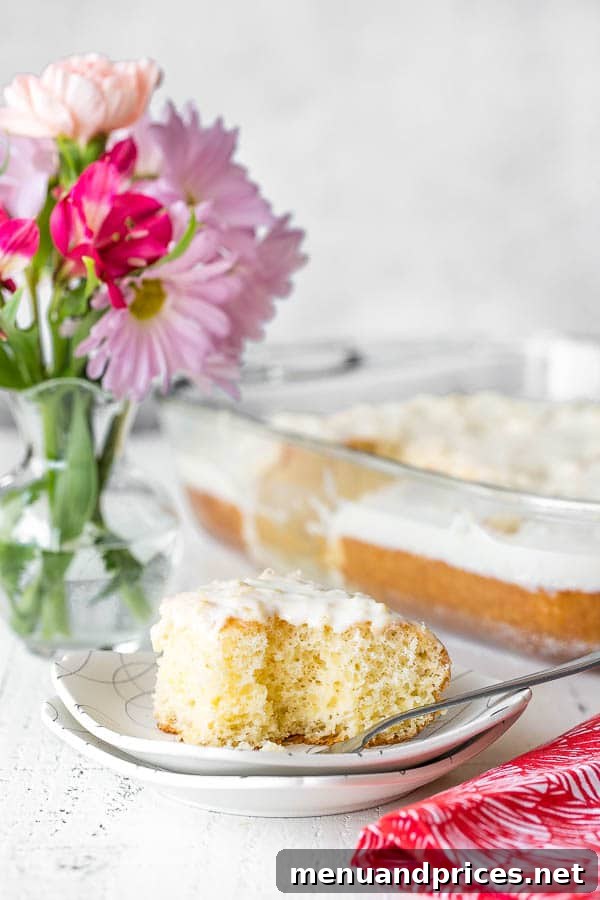 A slice of easy pineapple cake on a plate with a fork with a bite missing.