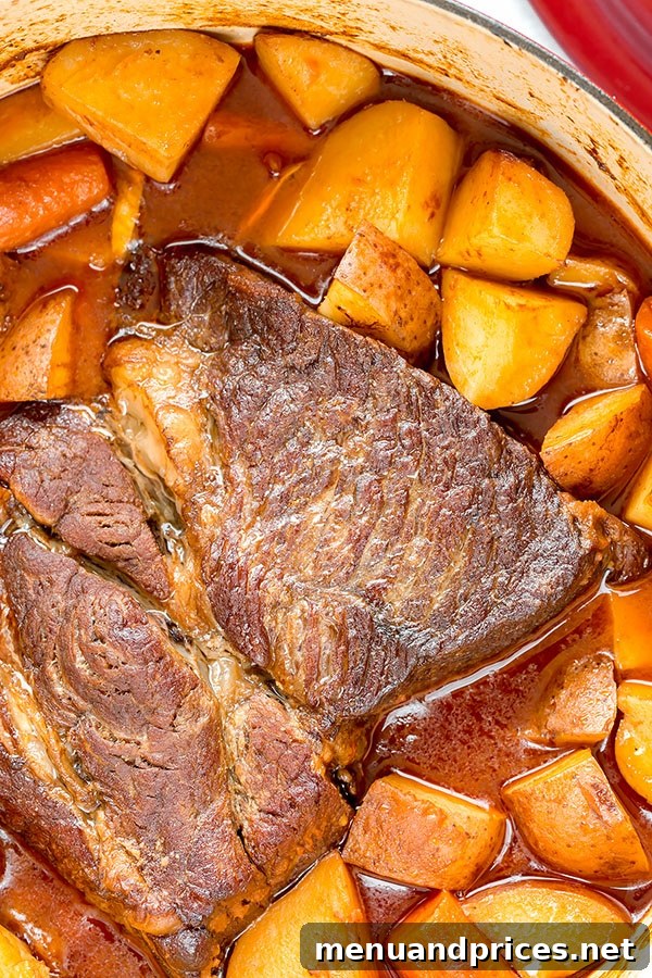 No-Fuss Pot Roast 6 A close-up of the finished pot roast in a Dutch oven, showcasing tender beef, carrots, and potatoes simmering in a rich, savory gravy after slow cooking.