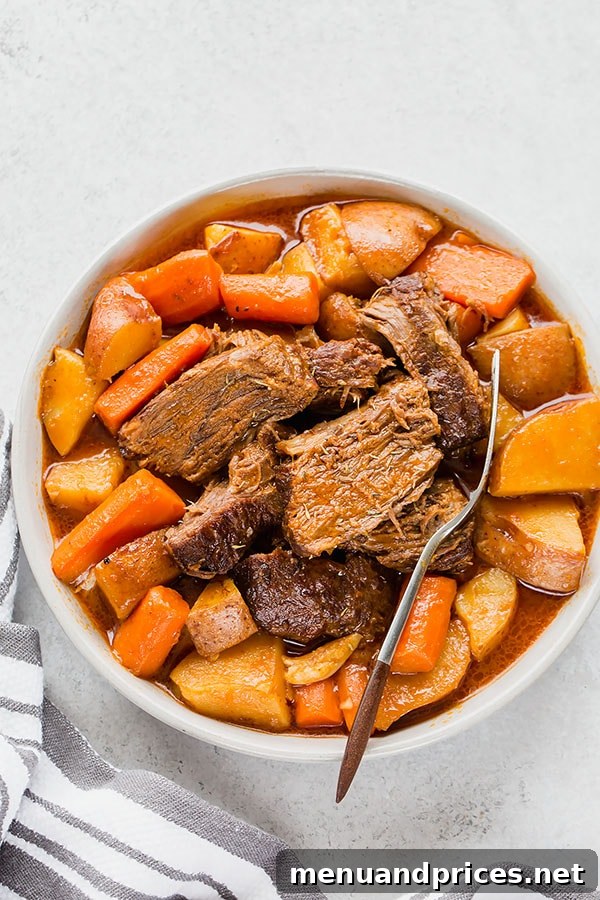 No-Fuss Pot Roast 7 A serving of classic Dutch oven pot roast with tender chuck roast, carrots, and potatoes, garnished and ready to be enjoyed as a hearty comfort meal.