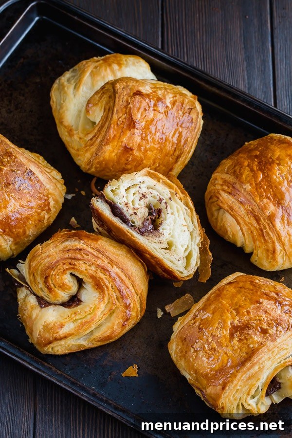 Close-up of a batch of homemade chocolate croissants dough showing beautiful, intricate layers formed during the meticulous lamination process. Making croissants from scratch becomes easier with patience and detailed guidance.
