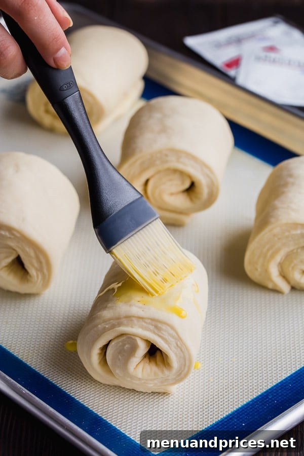 Pain au Chocolat pastries, meticulously brushed with an egg wash just prior to baking, a step that promises a beautiful golden-brown and shiny finish.