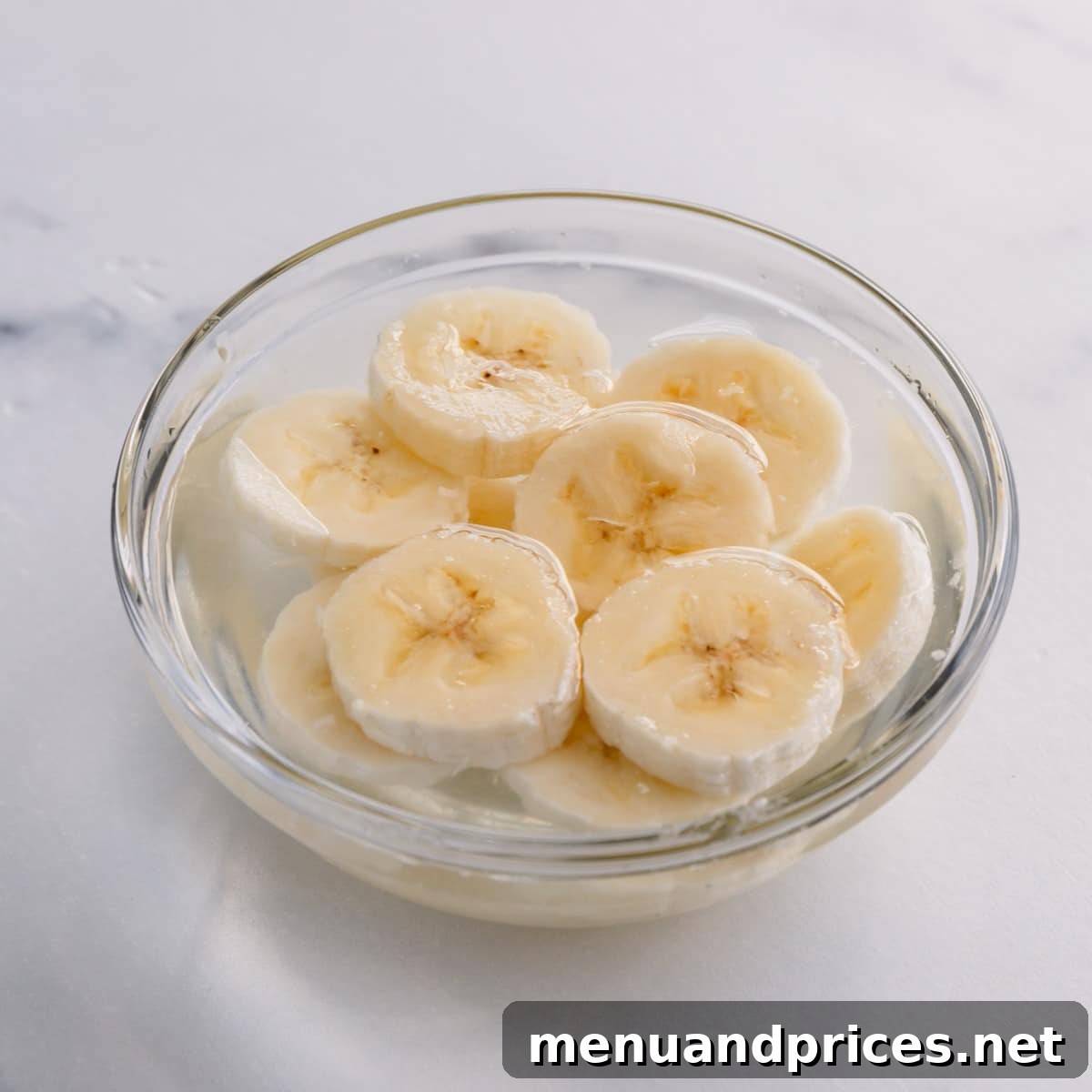 Luscious Banana Dream Pie 8 Fresh banana slices soaking in a small bowl of lemon water to prevent browning, a key step for a beautiful pie.