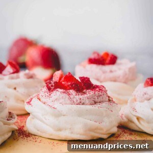 Mini strawberry pavlovas on a baking sheet.