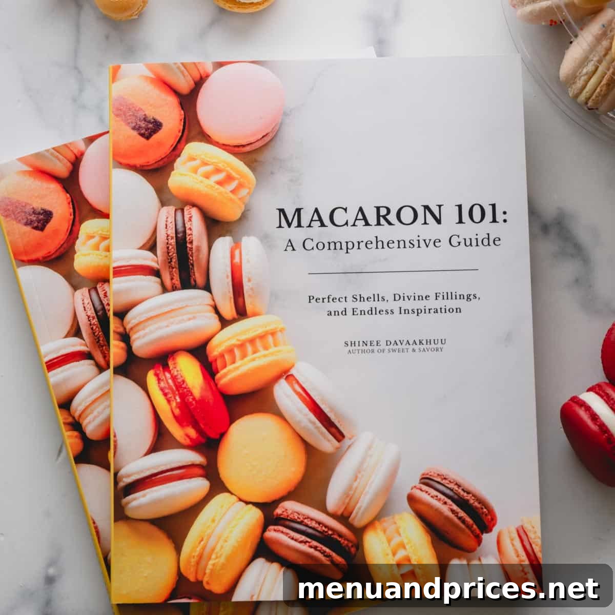 "Macaron 101" cookbook on a marble background.