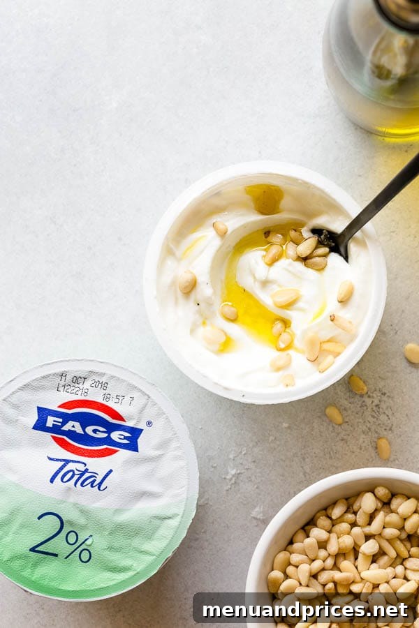 Crafting Your Dream Yogurt Bar 7 An unusual yet incredibly savory yogurt bowl featuring a drizzle of olive oil, a sprinkle of sea salt, and toasted pine nuts, promising to surprise and delight your taste buds. #yogurtbar #snack #healthysnack #snacktime #yogurtbowl