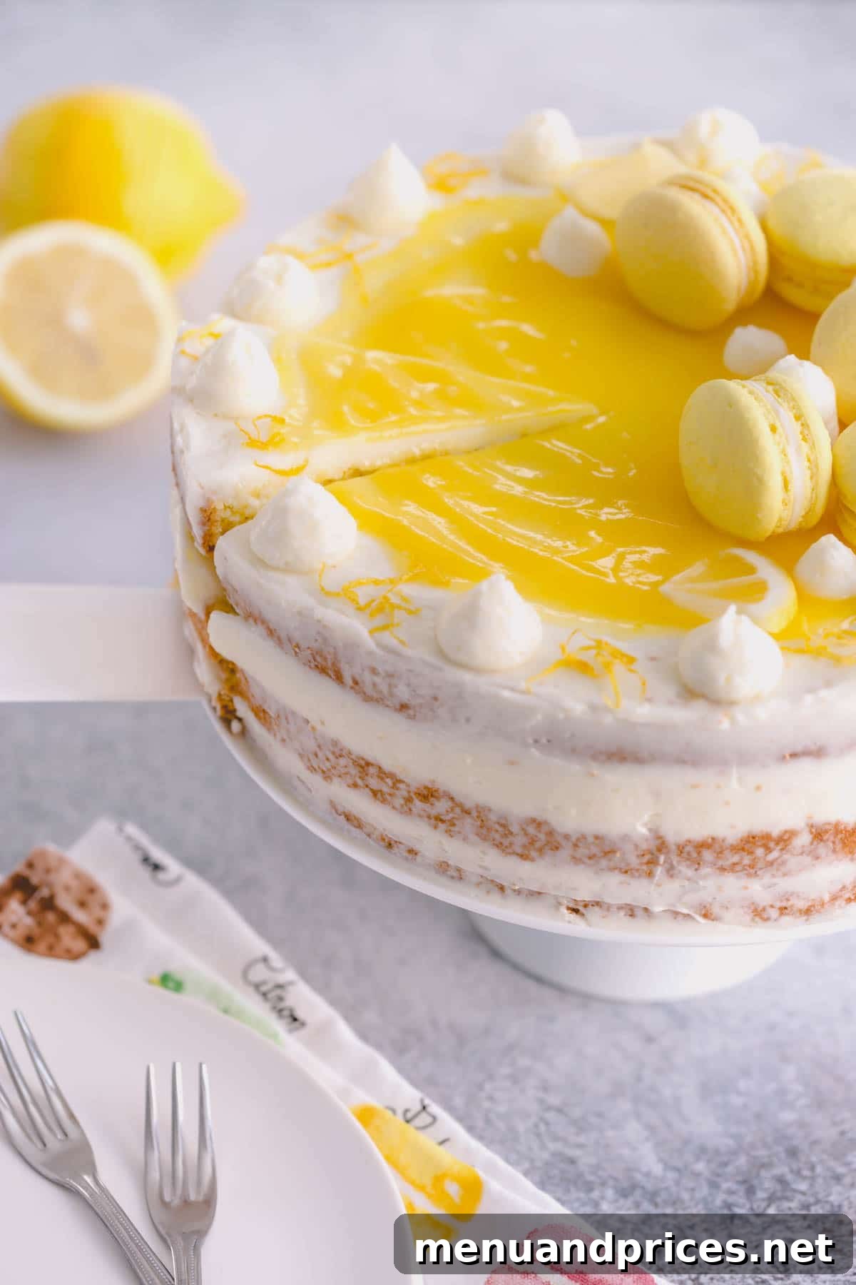 A beautifully decorated lemon layer cake on a cake stand, adorned with fresh lemon macarons, ready to be served and enjoyed.