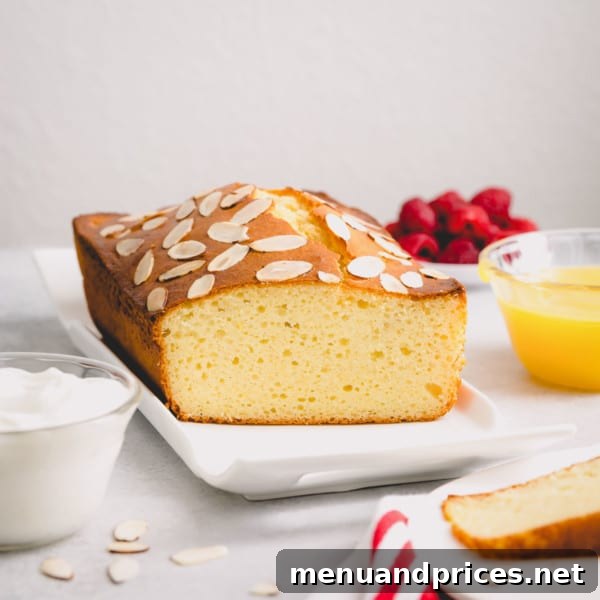 Yogurt-Kissed Almond Cake 6 A slice of almond yogurt cake topped with fresh raspberries and a dusting of powdered sugar.