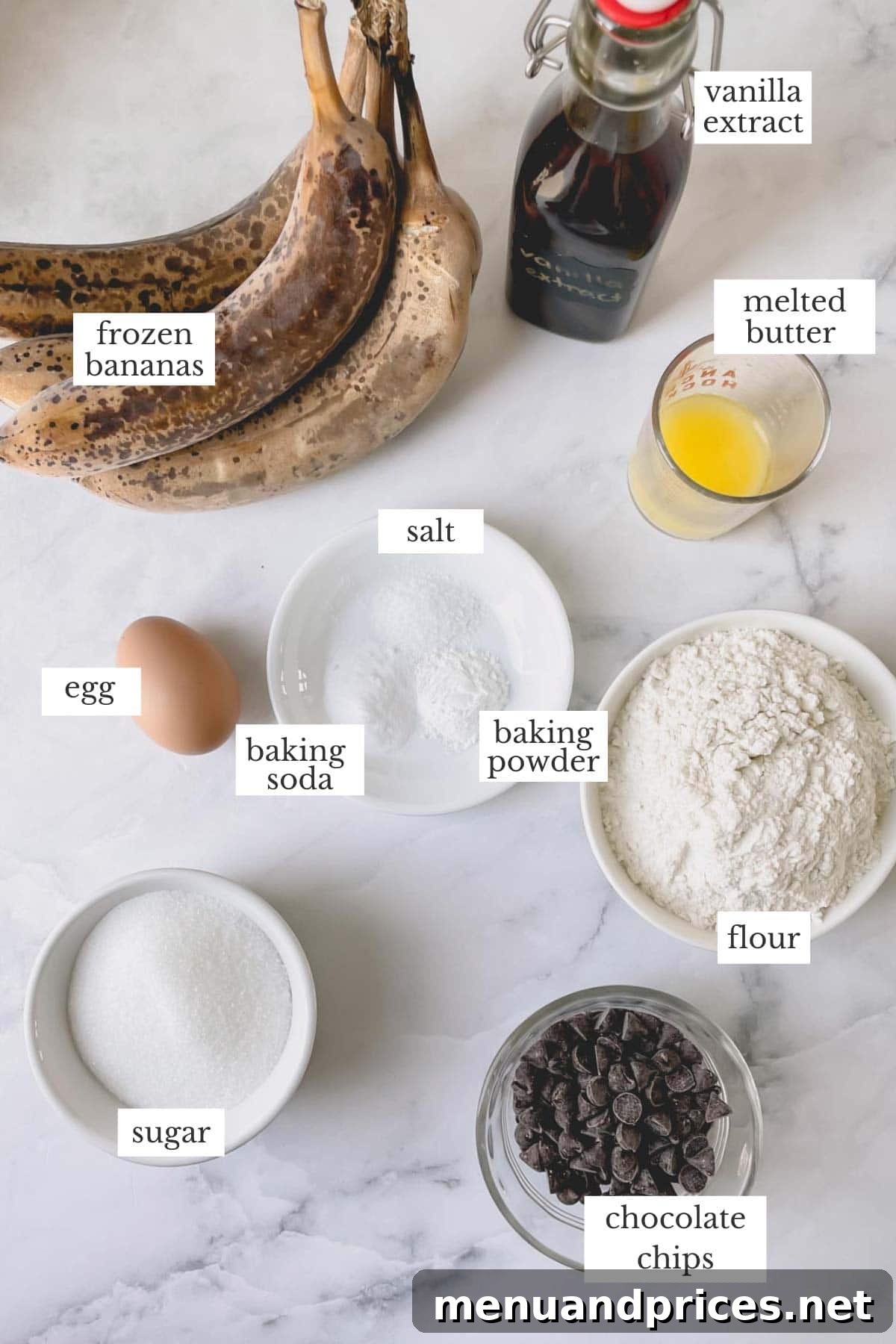 Deliciously Simple Banana Muffins 4 A collection of fresh ingredients laid out on a table, including ripe bananas, flour, melted butter, granulated sugar, and an egg, all ready for making delicious muffins.