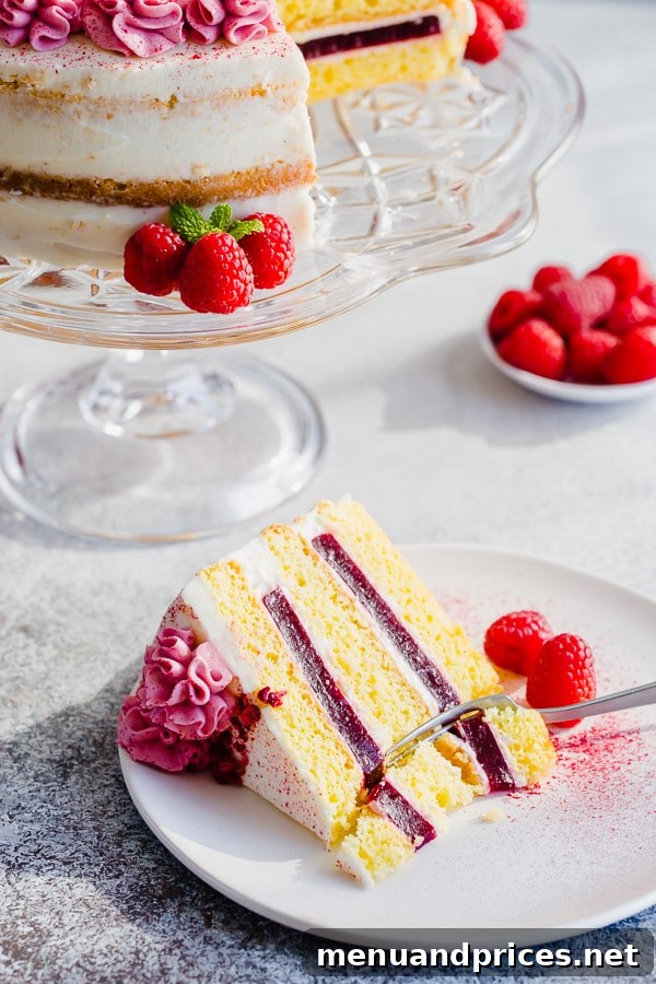 Side view of the impressive tall raspberry layer cake, showcasing its beautiful layers.