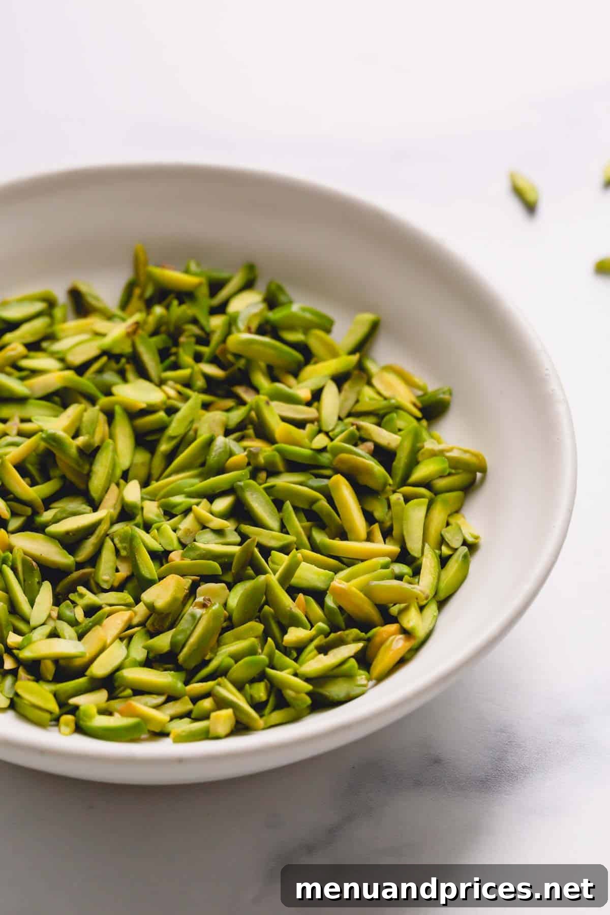 Easy Homemade Pistachio Paste Recipe 4 A bowl of slivered pistachios, a convenient option for making pistachio paste.