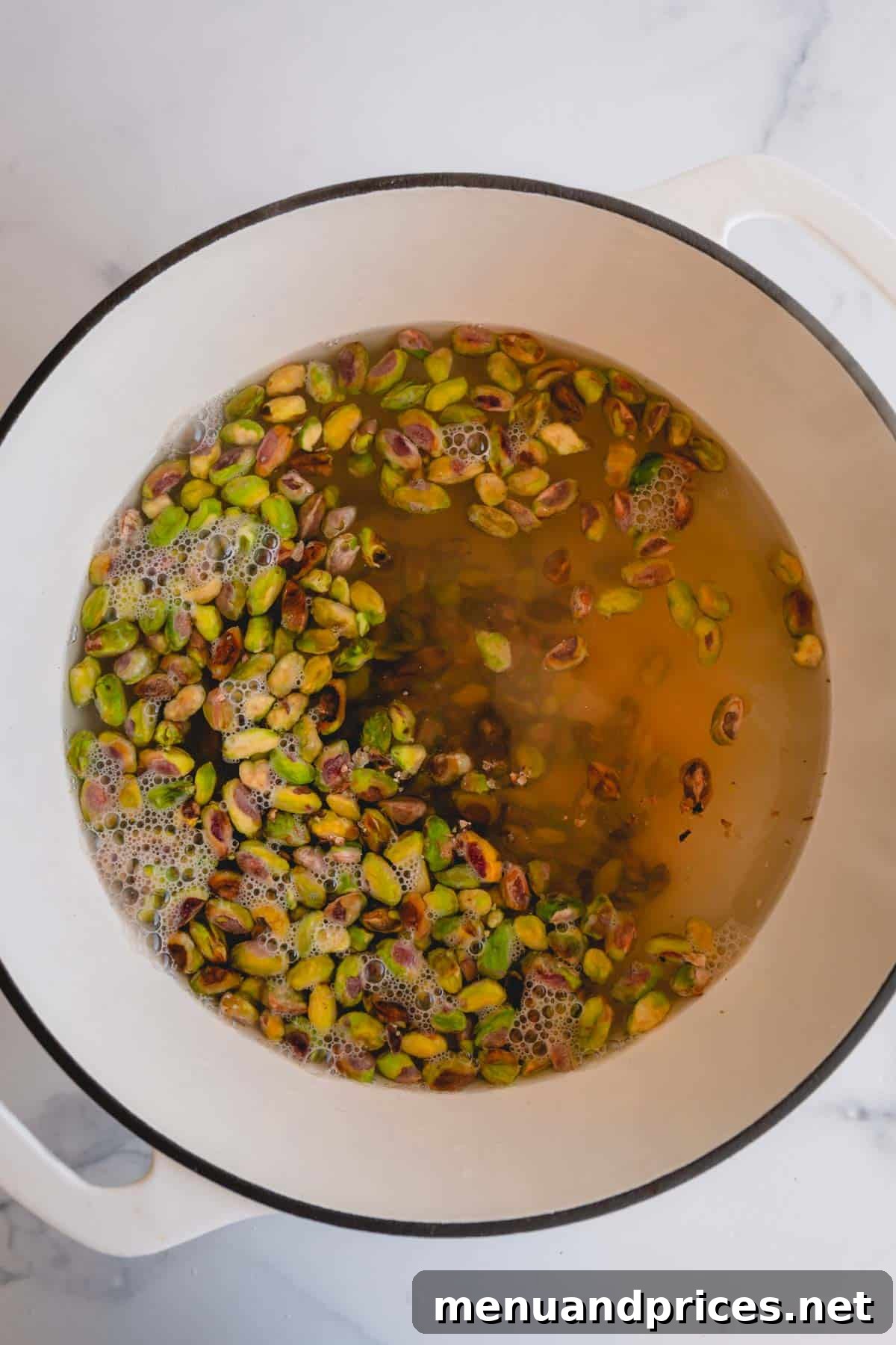 Easy Homemade Pistachio Paste Recipe 6 A pot of boiling water with raw pistachios being blanched.
