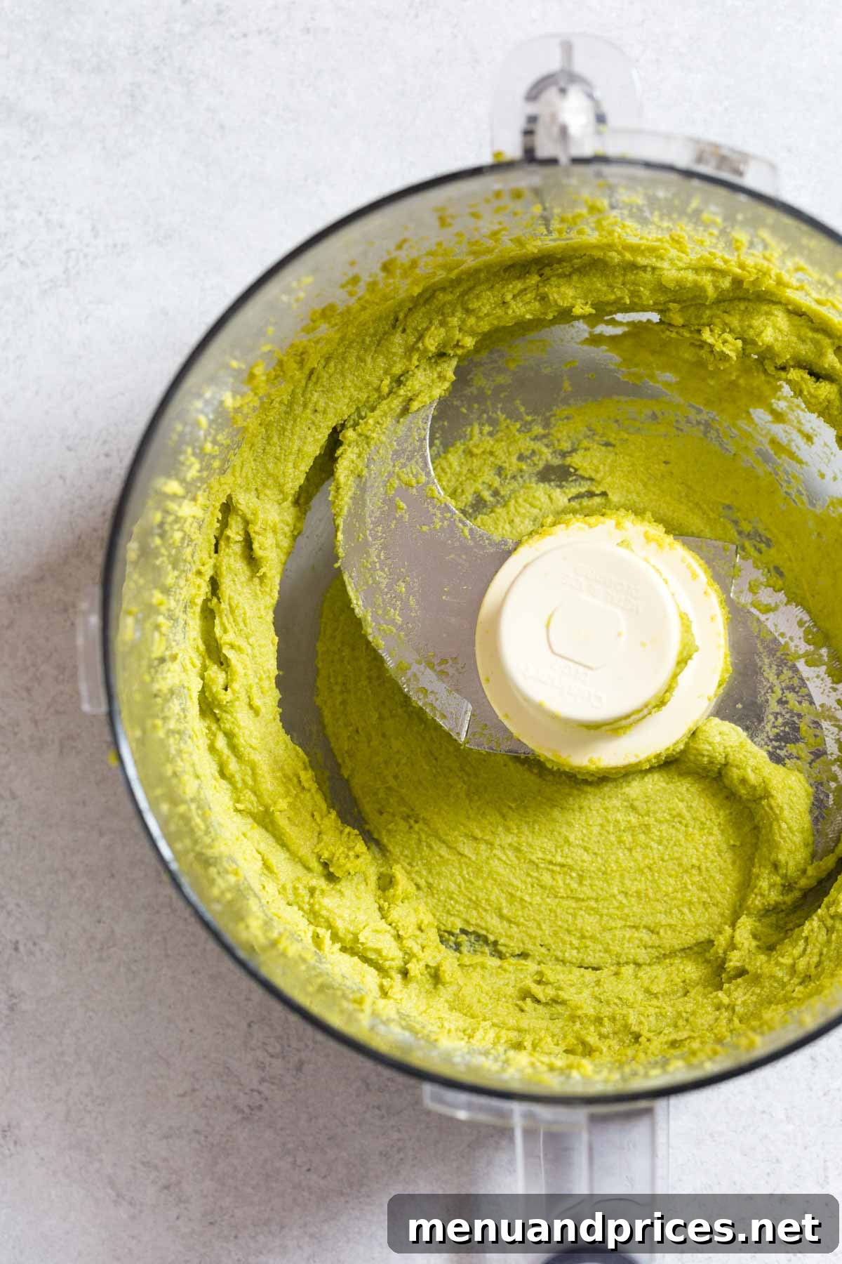Easy Homemade Pistachio Paste Recipe 8 Smooth, bright green pistachio paste being processed in a food processor.