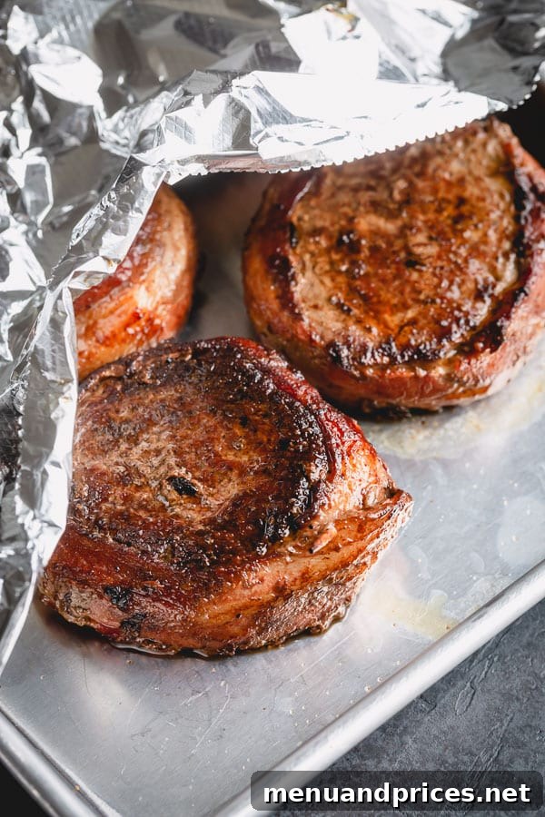 Filet mignon steaks cooking in a pan.